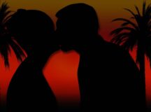 Couple kissing next to two palm trees