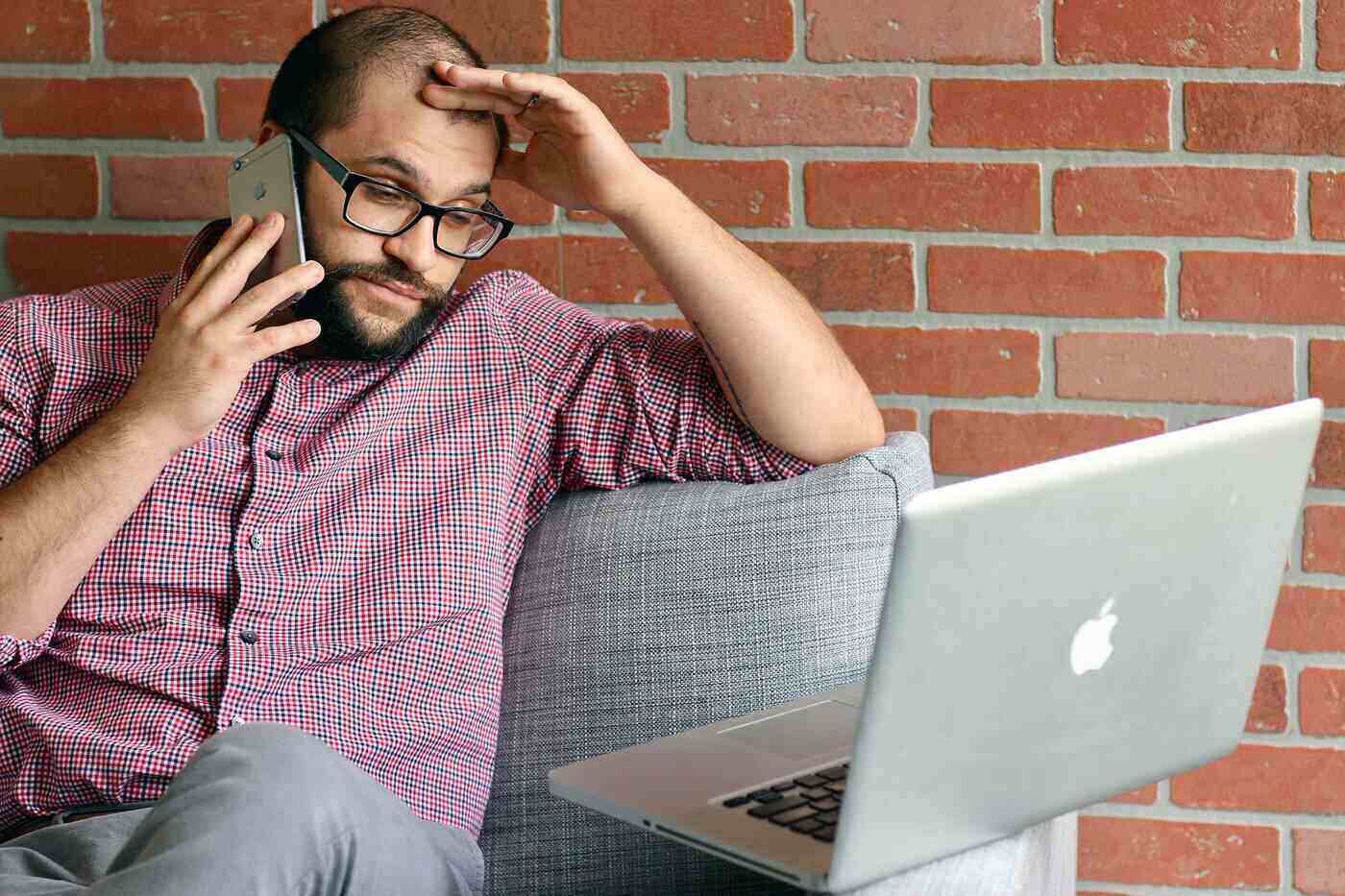 Frustrated businessman with laptop, on phone