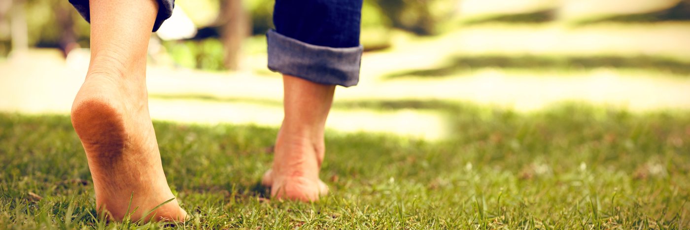 Person walking barefoot on grass